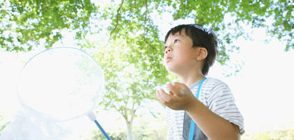 A young boy blowing bubbles from a bubble maker toy