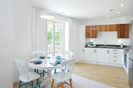 Tidy table and chairs, in white kichen with patio doors.