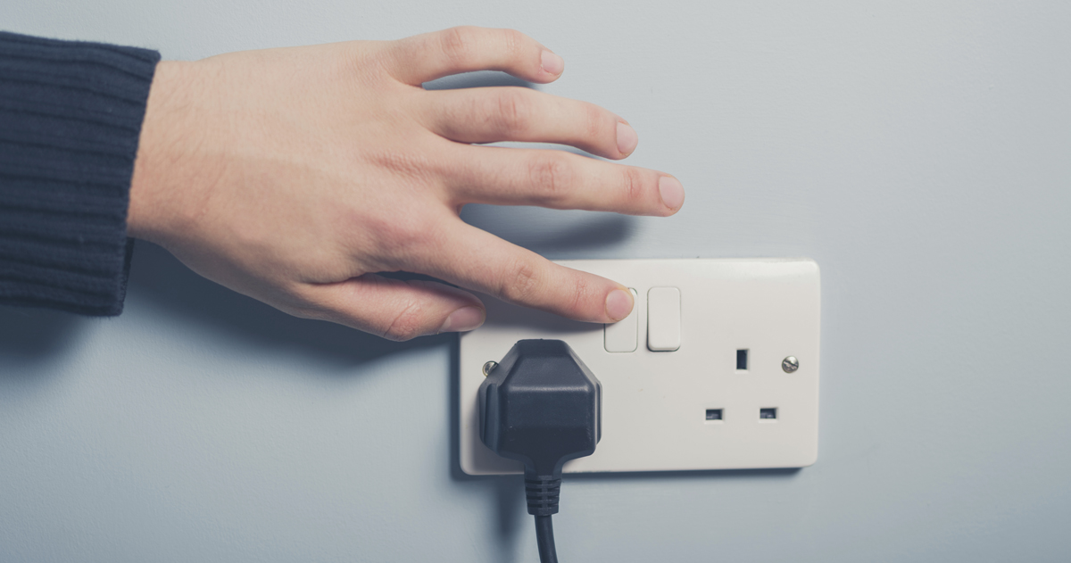 Male hand pressing a power switch on the wall