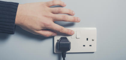 Male hand pressing a power switch on the wall