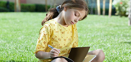 Young Girl Writing In Book Website
