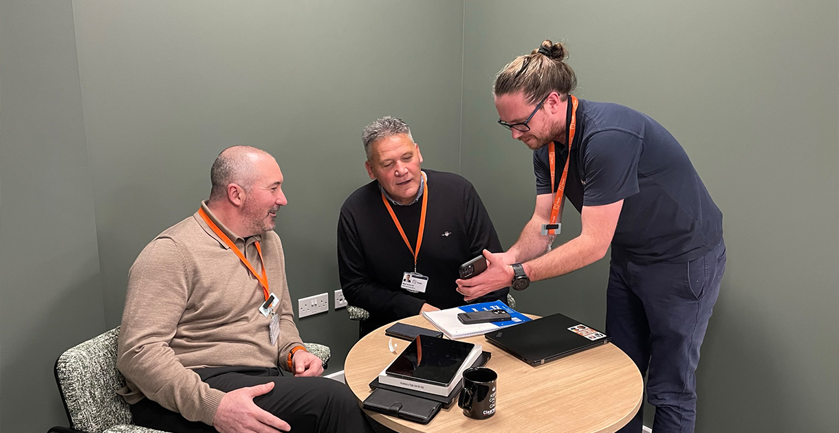 Mark, Neal and Tom looking at mobile - 1220x630